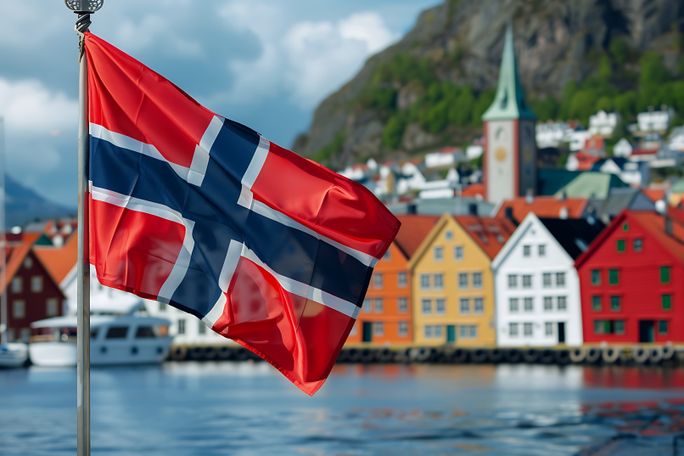 Norwegian national flag in front of colorful houses in Bergen, Norway. Norwegian national flag in front of colorful houses in Bergen, Norway.
