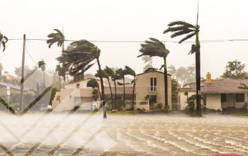 A residential neighborhood during a severe storm with strong winds and heavy rain.