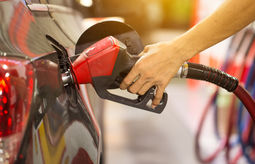 Pumping gas at gas pump.