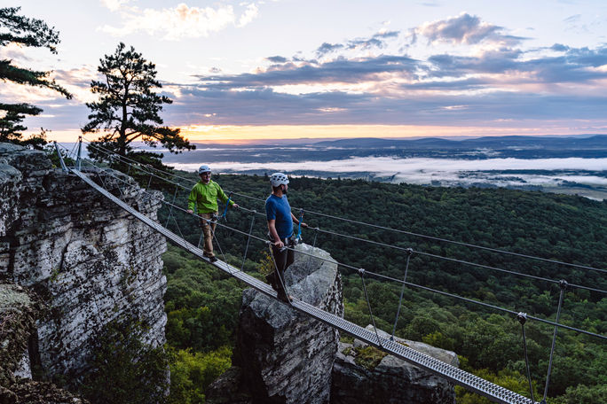 A father and son walk across a hanging bridge at Mohonk Mountain House. Mohonk Mountain House, hanging bridge, hiking, hiking experience, father's day, family travel