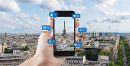 Smart phone taking a photo of the Eiffel Tower to post on social media.