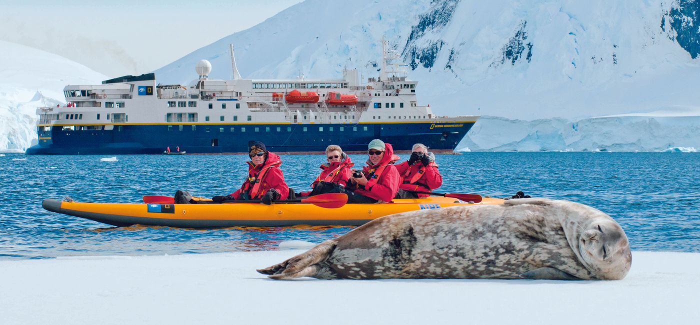 Image: Travelers in a kayak photograph a sleeping seal during a Lindblad Expeditions-National Geographic expedition cruise in Antarctica. (Photo Credit: Lindblad Expeditions-National Geographic)