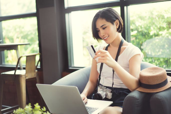 Traveling with Credit Card at coffee shop Woman holding credit card at coffe shop (Photo via torwai / iStock / Getty Images Plus)