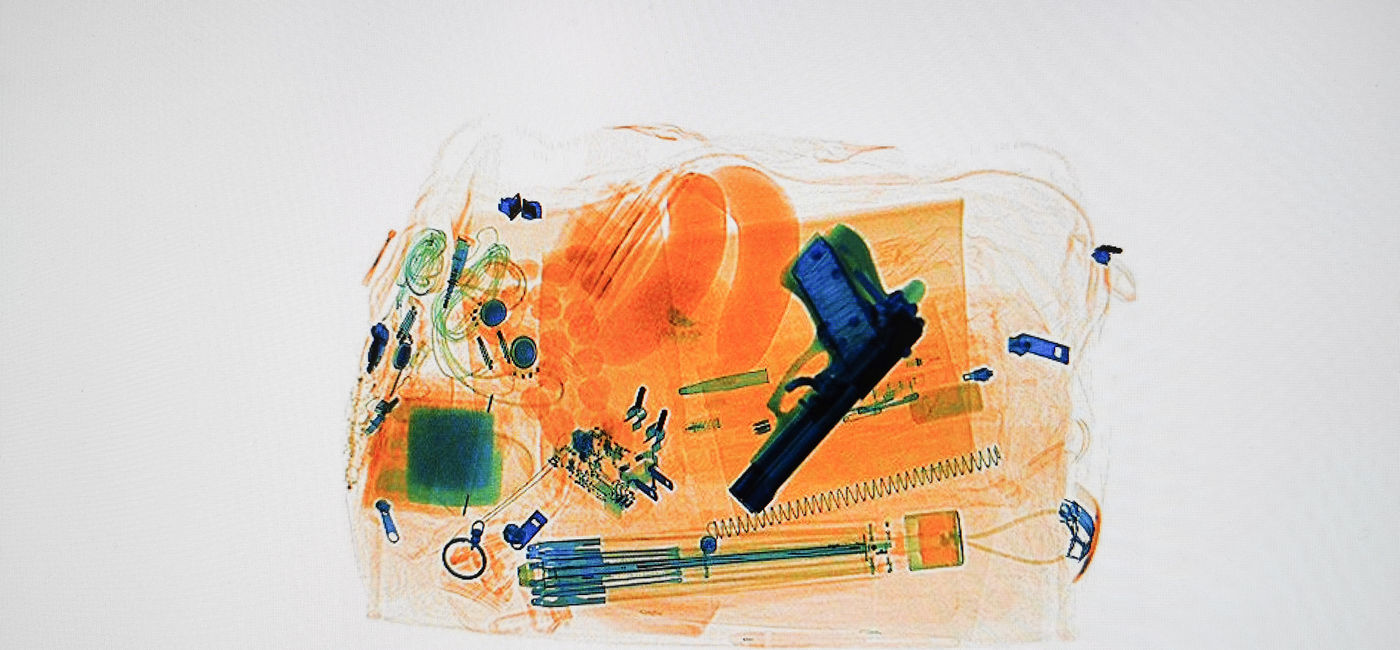 Image: Xray of luggage with a hidden pistol (Photo Credit: Thomas / Adobe Stock)