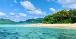 Island with turquoise water, white sand beach, blue sky