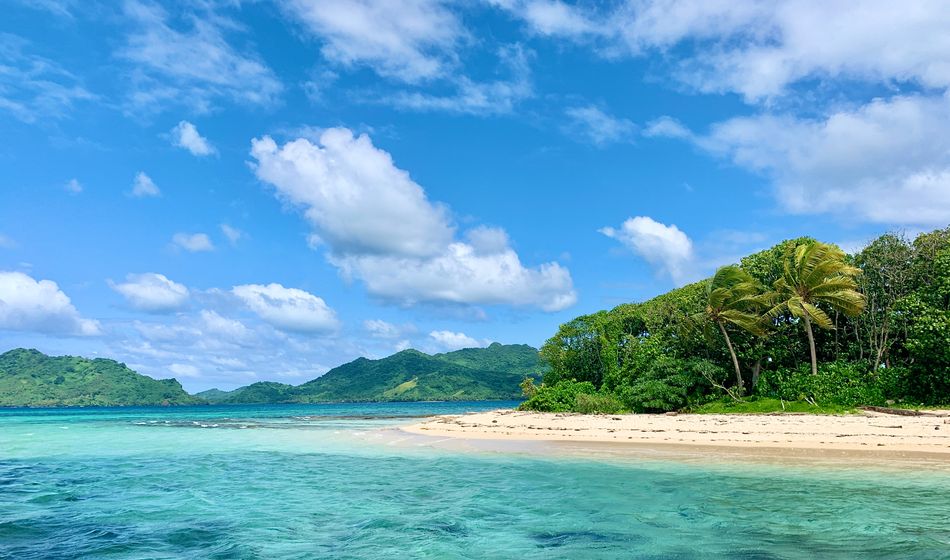Island with turquoise water, white sand beach, blue sky