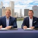 Jason Liberty, Chairman and CEO of Royal Caribbean Group, and Adam Stewart, Executive Chairman of Sandals Resorts, sign mega deal,
