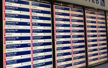 A monitor at Chicago's O'Hare International Airport shows multiple flight delays and cancellations.