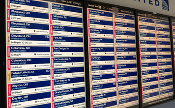 A monitor at Chicago's O'Hare International Airport shows multiple flight delays and cancellations.