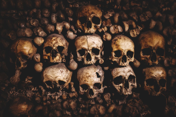 Human skulls and bones stacked up inside the Paris catacombs. Human skulls and bones stacked up inside the Paris catacombs.