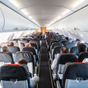 Passengers seated inside of a commercial airplane cabin.