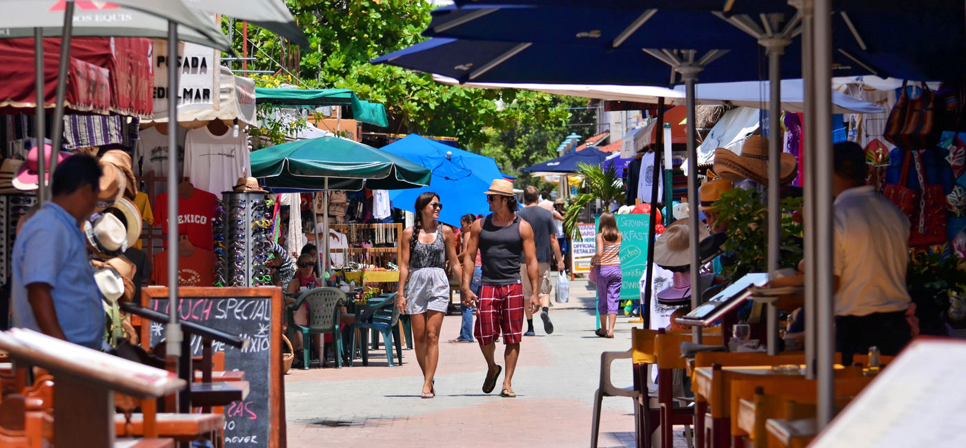Image: Tourists stroll through a market on Isla Mujeres, Quintana Roo, Mexico. (Photo Credit: Mexican Caribbean Tourism Board)