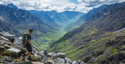 Hiker making his way down a steep trail in Alaska's Talkeetna Mountains.