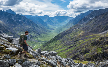 Hiker making his way down a steep trail in Alaska's Talkeetna Mountains.