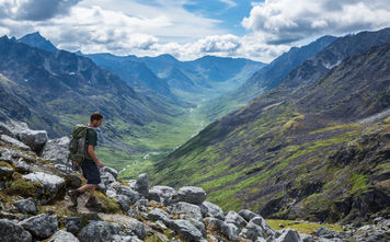 Hiker making his way down a steep trail in Alaska's Talkeetna Mountains.