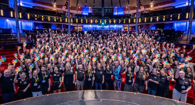 CoNexion attendees hold up their Nexion fans during a general session.