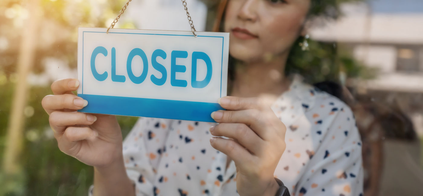 Image: Woman closing her business. (Photo Credit: Adobe Stock/geargodz)