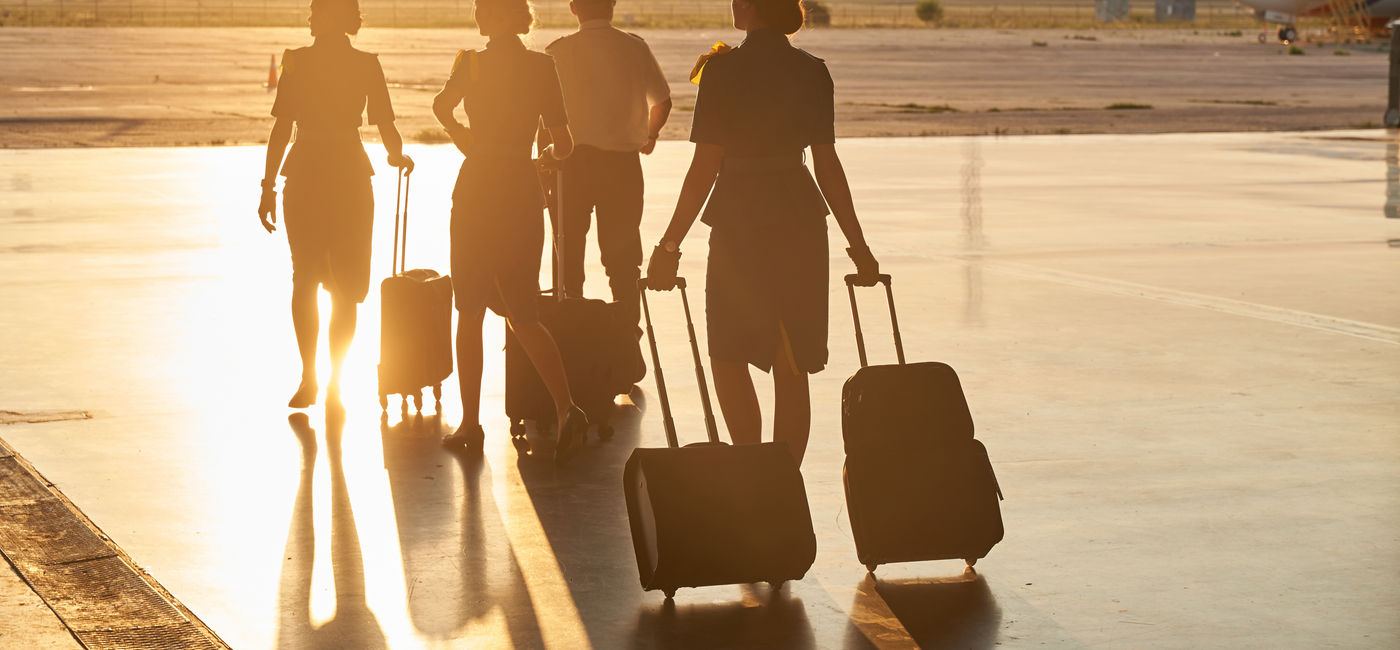Image: Flight attendants boarding a plane. (Photo Credit: Adobe/Svitlana)