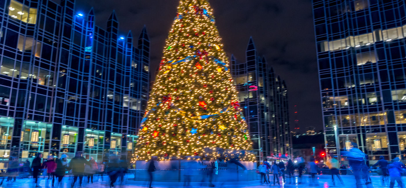 Image: People ice skating around a Christmas tree in Pittsburgh. (Photo Credit: Cole/Adobe)