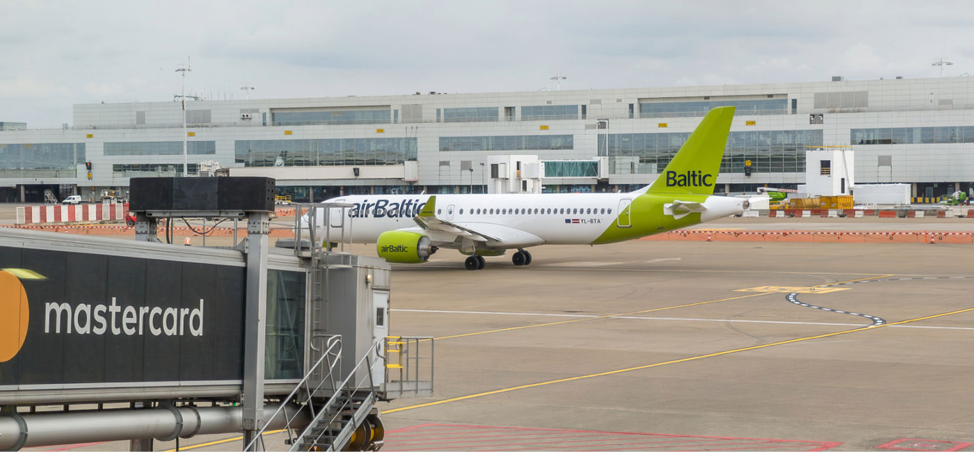 Image: An airBaltic plane taxis at the Brussels airport. (Photo Credit: Dirk / Adobe Stock)
