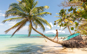 Woman walking on palm tree on beach