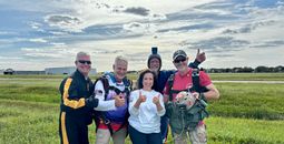 Carnival Cruise Line President Christine Duffy with members of the Round Canopy Parachute Team.