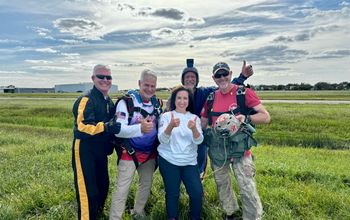 Carnival Cruise Line President Christine Duffy with members of the Round Canopy Parachute Team.
