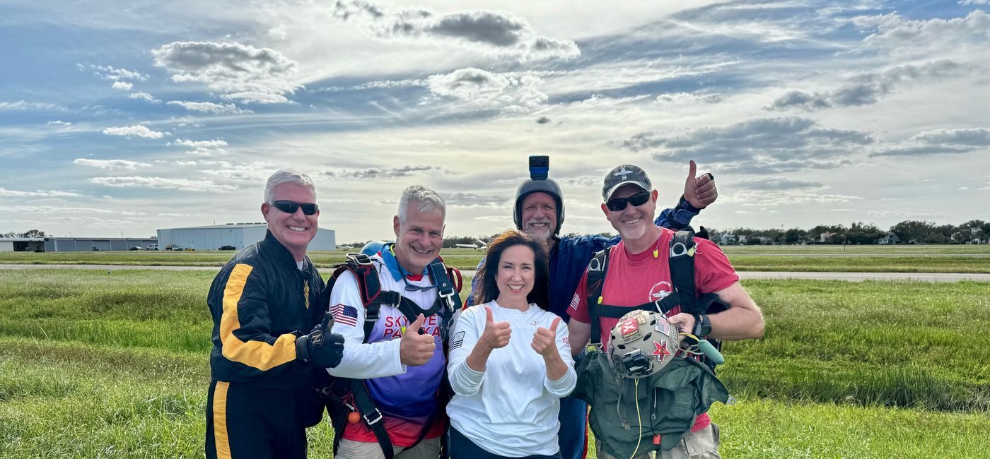 Image: Carnival Cruise Line President Christine Duffy with members of the Round Canopy Parachute Team. (Photo Credit: Carnival Cruise Line)