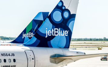Two JetBlue airplanes parked.