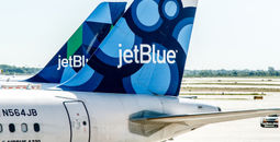 Two JetBlue airplanes parked.