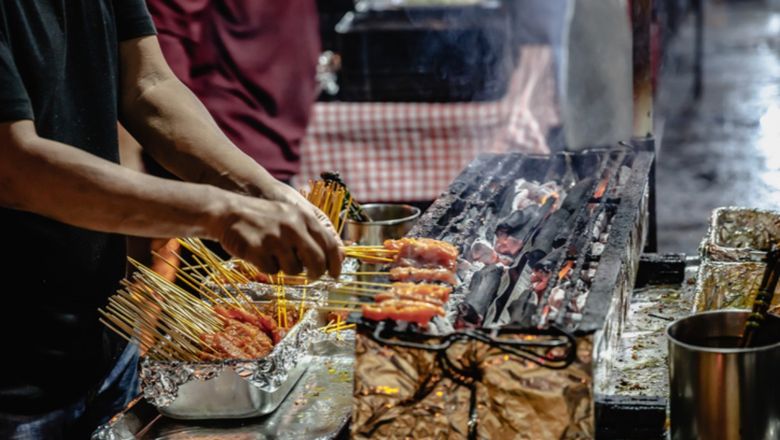 A grill and skewer expert at work on Lau Pa Sat hawker centre's  Satay Street, Singapore.