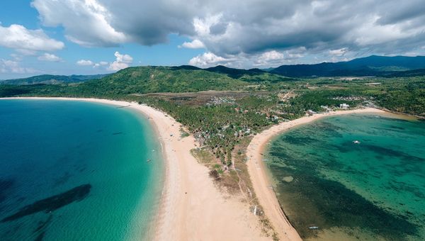 Nacpan Beach features two stunning beaches, Nacpan and Calitang, separated by a scenic sandbar, offering golden sands, crystal-clear waters, and breathtaking views.