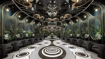 The bathroom entrance leads to a corridor adorned with plants.