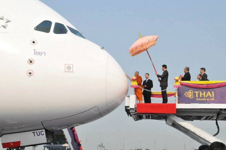 A monk blessing a Thai Airways aircraft.