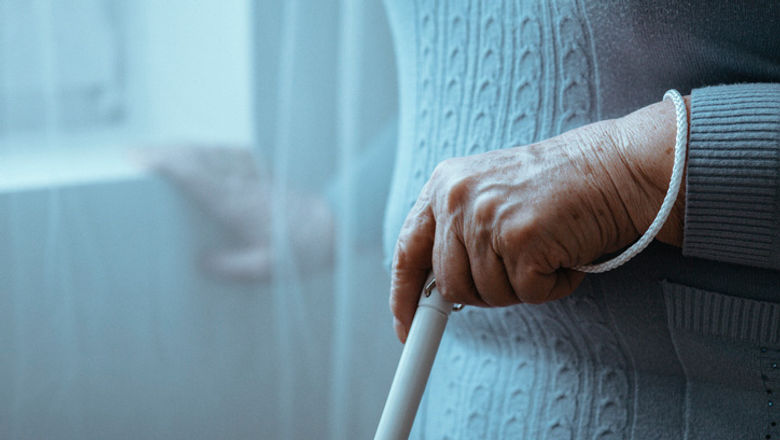 A visually-impaired person holding a white cane.