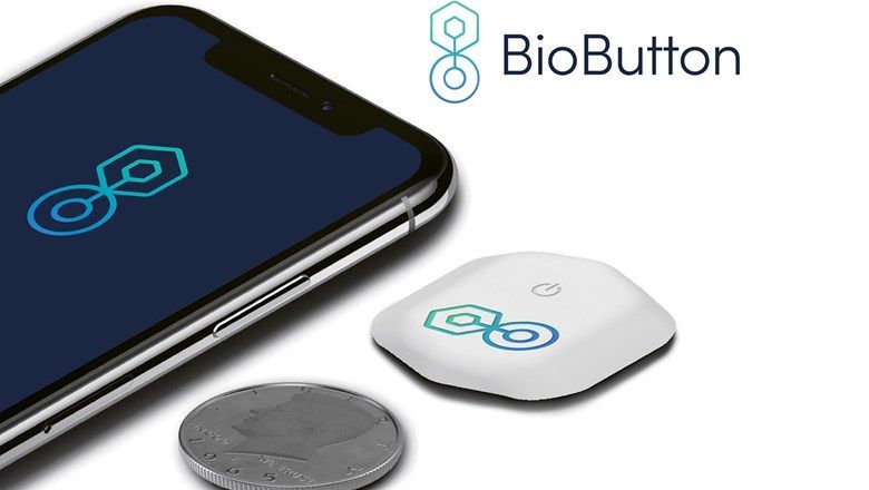BioIntelliSense's BioButton, shown with a smartphone and coin for scale, can track key health metrics.