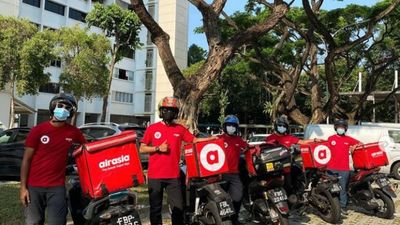 Not just in the skies only: AirAsia's red uniformed crew can now be spotted delivering food on Singapore's roads.