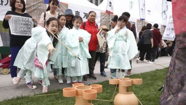 The traditional Korean game of Tuho and Arrows, taking aim into a pitch pot vase.