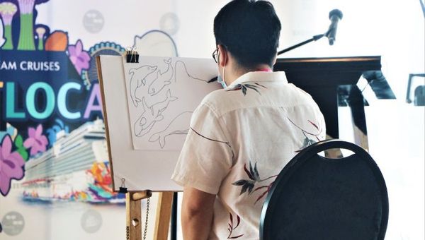 The Animal Project’s artist, Tay Jun-Yi, demonstrates how he draws the marine animals printed on the exclusive Dream Cruises denim pouch. The Animal Project’s artist, Tay Jun-Yi, demonstrates how he draws the marine animals printed on the exclusive Dream Cruises denim pouch.