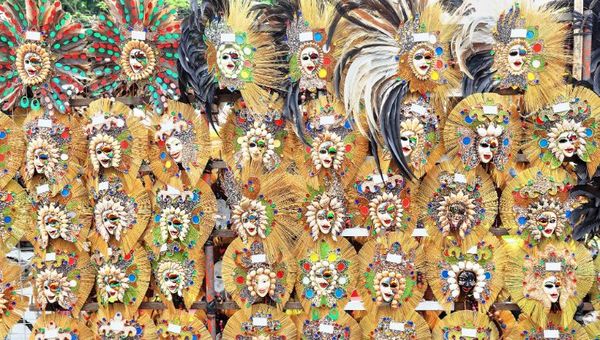Ornate smiling masks for sale in a street stall at the San Sebastian Cathedral entry for the MassKara annual festival held in Bacolod.