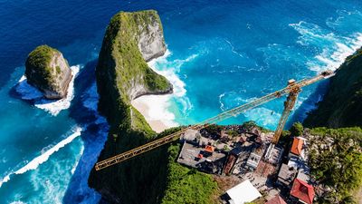 The half-finished glass elevator project at Kelingking Beach, one of Bali’s most photographed icons.