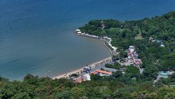 A bird's eye view of the Kep's coast, flanked by lush forests, hotels and restaurants.