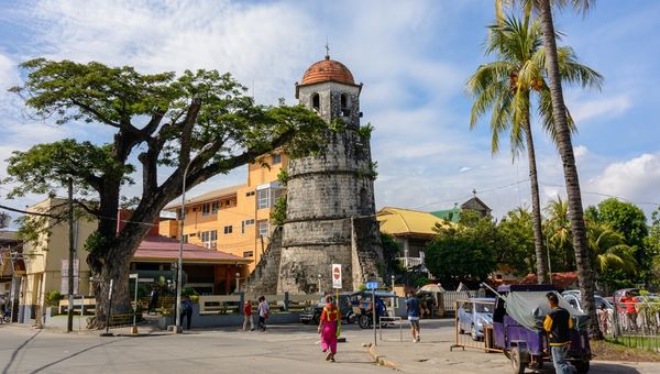 The Dumaguete Bell Tower, built in 1811, is a historic coral-stone structure once used to guard against pirates, now a cherished landmark beside the city cathedral.