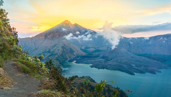 At Mount Rinjani National Park, travellers can expect scenic treks, stunning crater lakes, diverse wildlife, lush forests, and breathtaking views of Lombok's volcanic landscape.