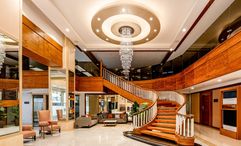 A sweeping staircase and chandelier frame the lobby at Best Western Plus Pulsar Cagayan.