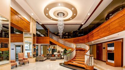 A sweeping staircase and chandelier frame the lobby at Best Western Plus Pulsar Cagayan.