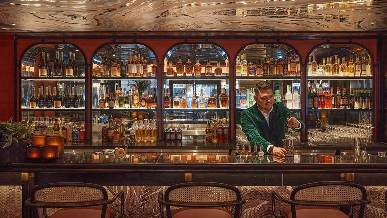Cygnet bar at QT Singapore offers a dynamic atmosphere, serving innovative cocktails crafted from local ingredients and complementing the steakhouse experience.