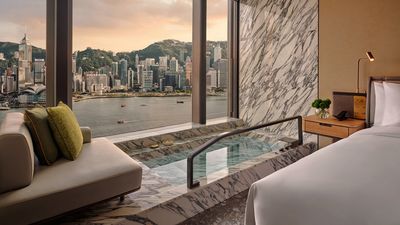 Select rooms at Kimpton Tsim Sha Tsui Hong Kong feature marble-framed plunge baths with harbour views.