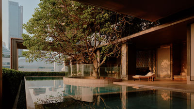 The hotel’s swimming pool is surrounded by Nai Lert Park’s lush greenery, offering a tranquil spot for relaxation under the shade of Bangkok’s third tallest tree.