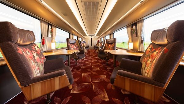 Japan’s Hana Akari, a scenic train by JR West, features plush swivel chairs and private seats, offering journeys through West Japan’s natural beauty and cultural landmarks.